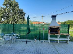 a patio with a fireplace and a table and chairs at BIULES - LA COLINA in Arnuero