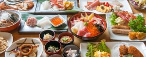 une table remplie de différents types de denrées alimentaires sur des assiettes dans l'établissement Onyado Nono, à Sakaiminato