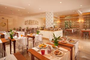 um restaurante com mesas e cadeiras com comida em Hotel Piccolo Borgo em Roma