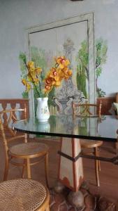 un tavolo di vetro con un vaso con fiori gialli di Casa Arezzola a Spoleto