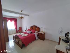 Schlafzimmer mit einem Bett mit einer roten Tagesdecke in der Unterkunft Vivenda Diniz in Silves