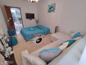 a living room with a white couch and a bed at Vivenda Diniz in Silves