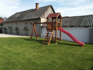 a playground with a red slide in a yard at Villa Cuba in Veľký Meder