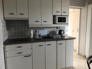 cocina con armarios blancos y microondas en Apartament Nordic en Trzęsacz