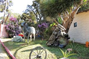 a statue of a goat standing in a yard at Pousada Juriti - Eco Hotel in São Roque