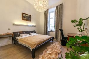 a bedroom with a bed and a desk and a window at Freta Unique Old Town Apartment in Warsaw