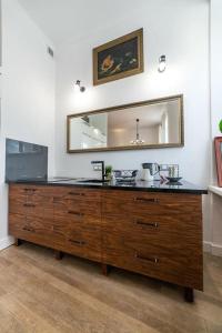 a large wooden dresser with a mirror in a room at Freta Unique Old Town Apartment in Warsaw