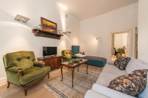 a living room with a couch and chairs and a tv at Freta Unique Old Town Apartment in Warsaw