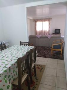 sala de estar con mesa y sofá en Casa sobrado, en Campos do Jordão