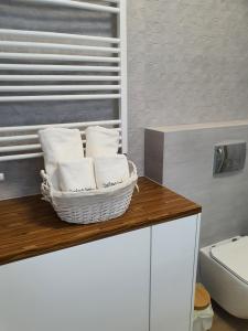 a bathroom with a basket of towels on a counter at Apartament SZAFIROWY Gardenia Dziwnów z widokiem na morze in Dziwnów +33 photos