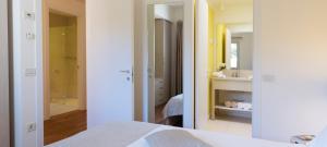 1 Schlafzimmer mit einem weißen Bett und einem Badezimmer in der Unterkunft DIEHOLIDAYBUCHT in Biograd na Moru