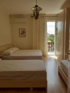 een hotelkamer met 2 bedden en een raam bij Guest House Zadeja in Shkodër