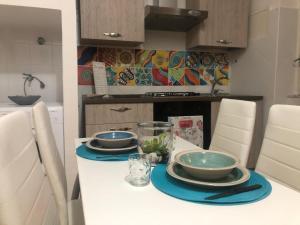 a kitchen with a table with plates and bowls on it at MACALELU HOUSE in Vietri sul Mare +13 photos