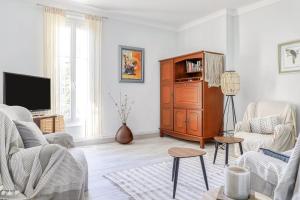 een woonkamer met een bank en een tv bij Charming Apt Near The Croisette in Cannes