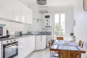 een keuken met witte kasten en een houten tafel bij Charming Apt Near The Croisette in Cannes