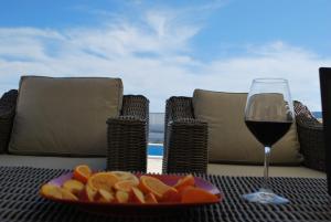 een schaal fruit en een glas wijn op een tafel bij Vila Bella Vista in Herceg-Novi