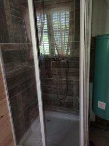 a shower with a glass door in a bathroom at BUNGALOV COZY UNA in Kulen Vakuf