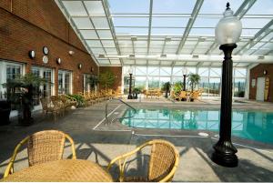 a lobby with a pool and chairs and a building at Carlisle Inn in Sugarcreek +19 photos