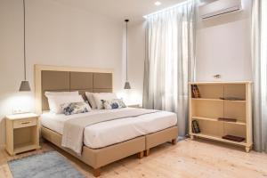 1 dormitorio blanco con 1 cama grande y estante para libros en Archontiko Contessina Angelika, en Corfú