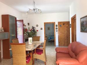ein Esszimmer und ein Wohnzimmer mit einem Tisch und einem Sofa in der Unterkunft VILLA PINETA VISTA MARE in San Menaio