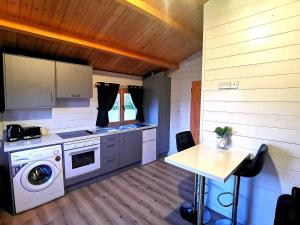 uma cozinha com uma máquina de lavar roupa e uma mesa em Westport Country Chalets em Westport