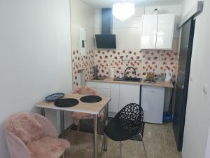 a kitchen with a table and chairs and a sink at Wrzosówka pokój z aneksem in Jelenia Góra