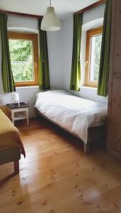 VillnossにあるArnika 1921のベッドルーム1室(緑のカーテン付きの大型ベッド1台付)