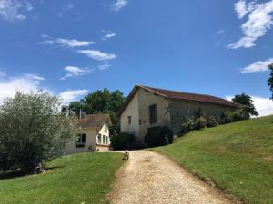 a dirt road next to a building on a hill at Maison Lamothe in Flamarens