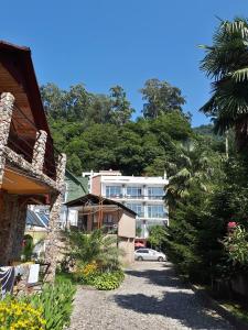 a street with a building and a palm tree at Hotel Del Mar in Kvariati