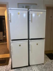 two refrigerators are standing next to each other in a room at Kwaterka in Brenna