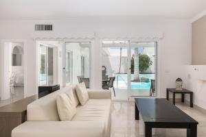 een woonkamer met een witte bank en een tafel bij Bahiazul Villas Corralejo by Vreagestion in Corralejo