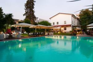 een groot blauw zwembad met tafels en parasols bij Villa Maria Cristina in Caserta