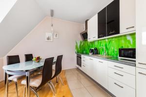 グダニスクにあるHappy Stay Old Town Tartaczna 235の緑の壁、ダイニングテーブル付きのキッチンが備わります。