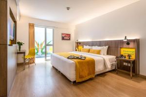 una camera da letto con un grande letto con una coperta gialla di Libre Hotel, BW Signature Collection by Best Western a Lima