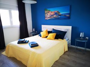 niebieska sypialnia z łóżkiem i dwoma ręcznikami na nim w obiekcie Apartment Sunrise, coastal Istra, Pula Duga Uvala Pavićini w mieście Pavicini
