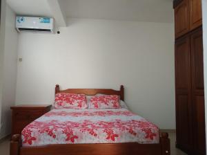 una camera da letto con un letto con un piumone rosso di Mandariniers 97232 a Le Lamentin