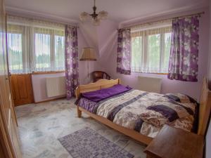 1 dormitorio con 1 cama y cortinas y ventanas moradas en Willa Cicha Woda, en Murzasichle