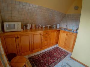 uma cozinha com armários de madeira e um micro-ondas em Willa Cicha Woda em Murzasichle