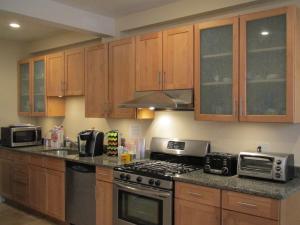 cocina con armarios de madera y horno con fogones en Bowers House Bed and Breakfast en Somerville