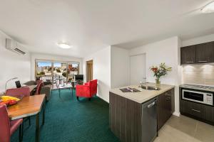 a kitchen and living room with a table and a couch at Melbourne Carlton Central Apartment Hotel Official in Melbourne +5 photos