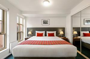 a hotel room with a large bed with red pillows at Melbourne Carlton Central Apartment Hotel Official in Melbourne