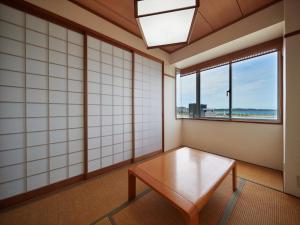 une chambre avec une table et deux fenêtres dans l'établissement Ocean Resort PMC, à Onna