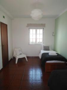 a white room with two beds and a window at Ergobeach House in Almograve