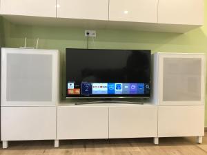 a flat screen tv sitting on top of a white cabinet at La Perla Playa apartamento a estrenar in Benalmádena