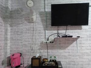 pared de ladrillo blanco con TV de pantalla plana en เซราะกราว บูติก รีสอร์ท Sohground Boutique Resort, en Prakhon Chai