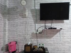 a white brick wall with a flat screen tv at เซราะกราว บูติก รีสอร์ท Sohground Boutique Resort in Prakhon Chai