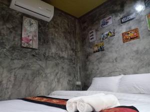 1 dormitorio con 2 camas y pared de piedra en เซราะกราว บูติก รีสอร์ท Sohground Boutique Resort, en Prakhon Chai