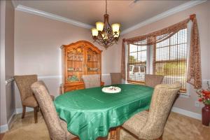 a dining room with a green table and chairs at 612 Egret Run Cabin in North Myrtle Beach