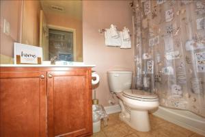 a bathroom with a toilet and a shower curtain at 612 Egret Run Cabin in North Myrtle Beach +12 photos