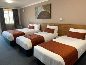 a hotel room with two beds in a room at In Town Motor Inn in Taree